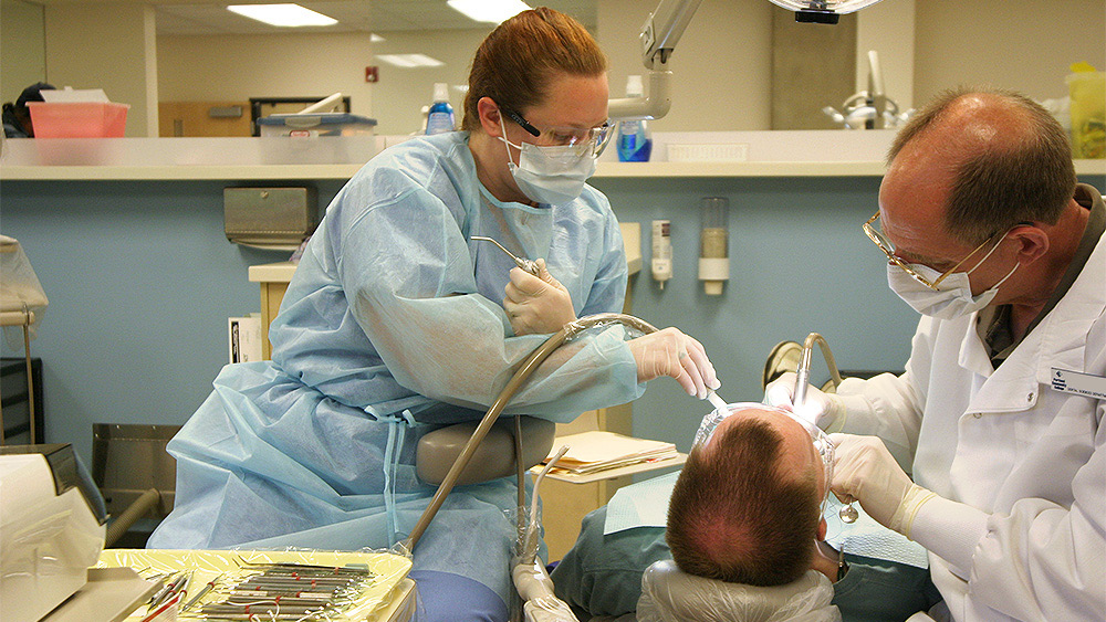 Student working as an assistant on a dental patient
