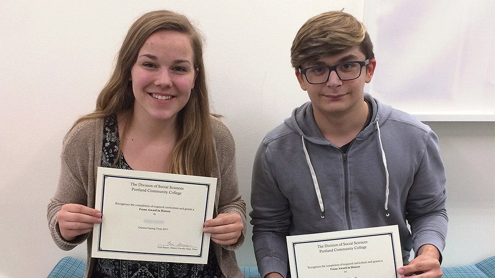 Two students holding their focus awards