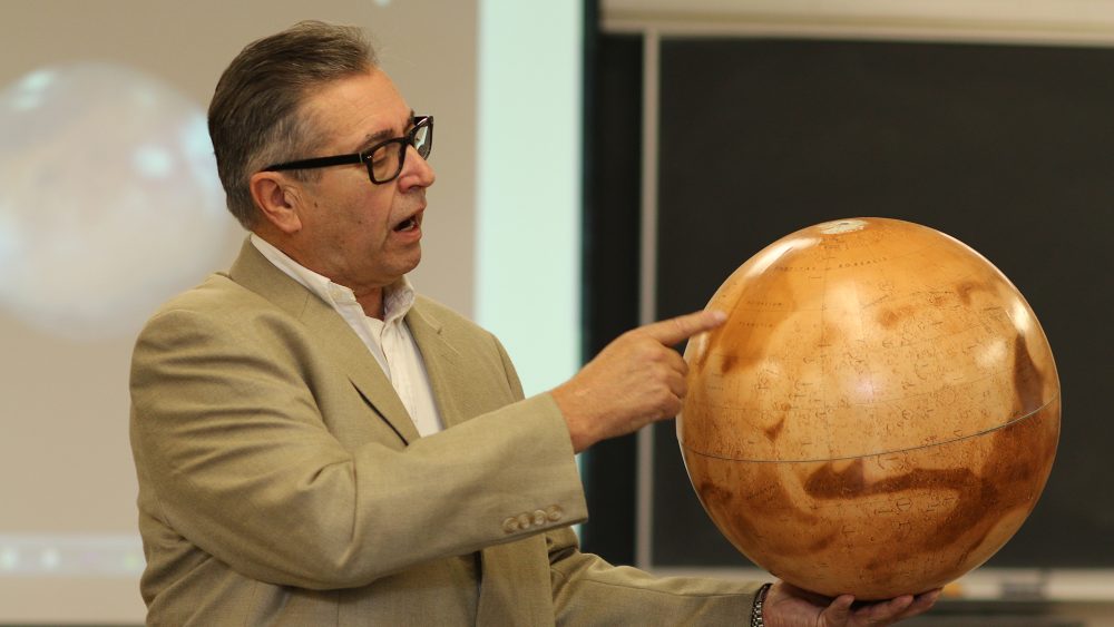 Instructor pointing to spot on globe
