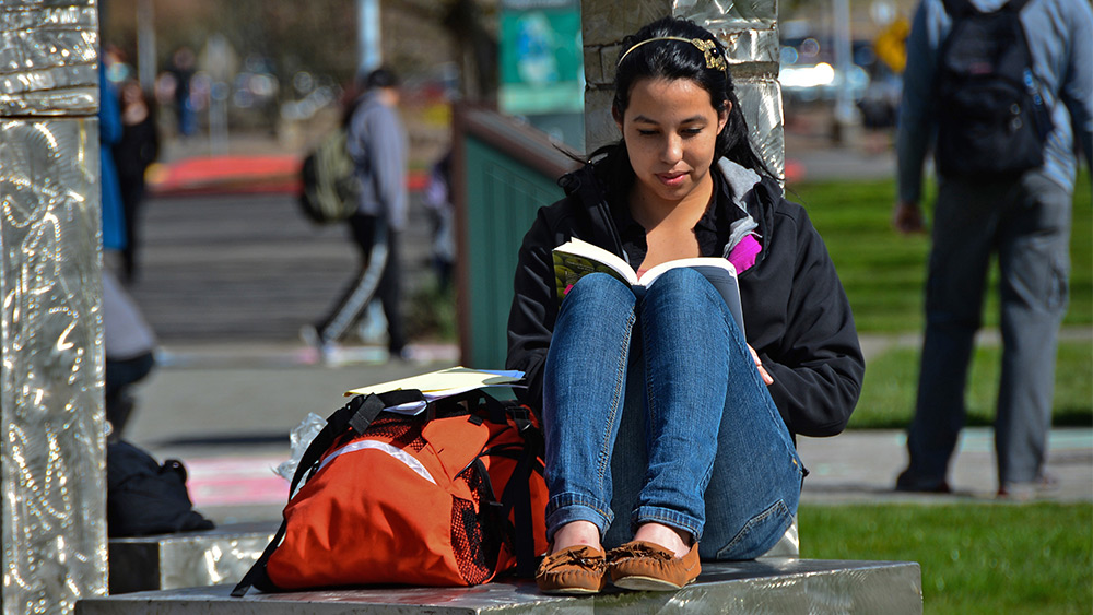 Student reading outside on campus