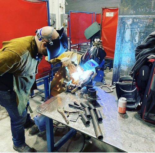 Classroom of students welding together
