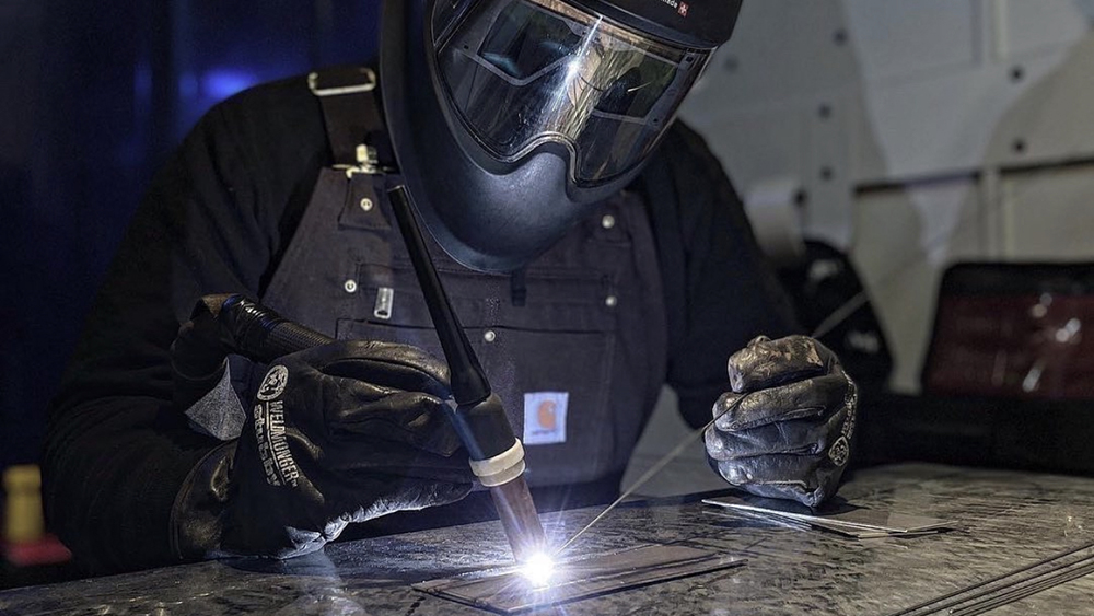 student welding in protective gear